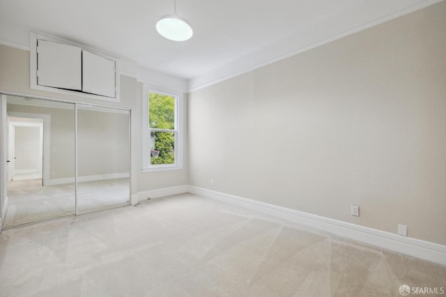 unfurnished bedroom with light carpet and a closet