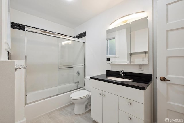 full bathroom featuring tile patterned floors, bath / shower combo with glass door, toilet, and vanity