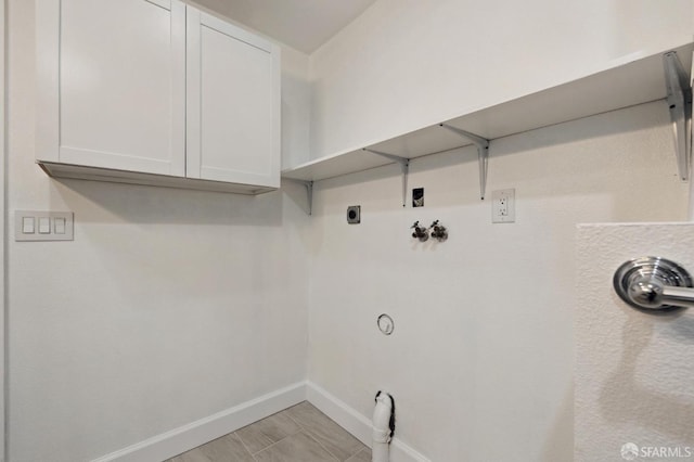 washroom with hookup for a washing machine and cabinets