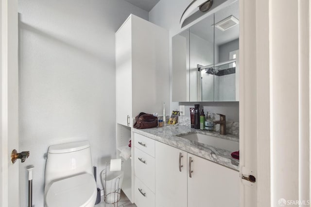 bathroom featuring a shower, toilet, and vanity