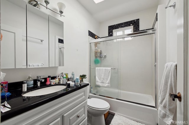 full bathroom featuring toilet, enclosed tub / shower combo, and vanity