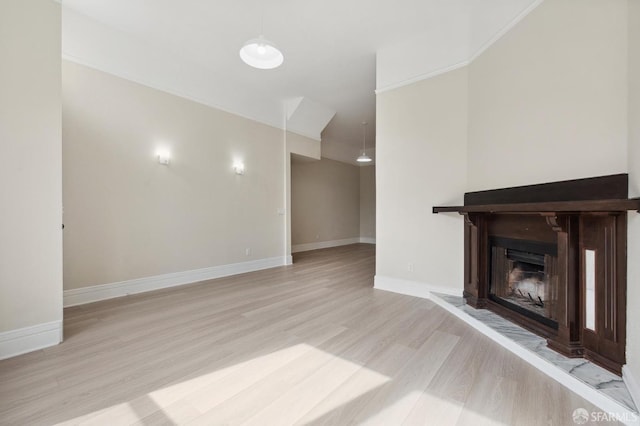 unfurnished living room featuring ornamental molding and light hardwood / wood-style flooring