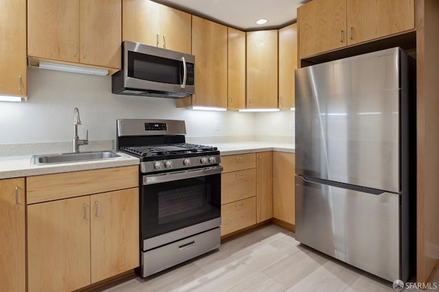 kitchen featuring light brown cabinetry, sink, and stainless steel appliances