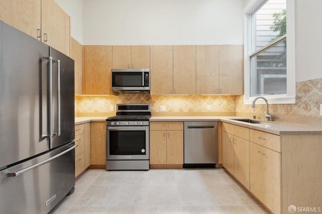 kitchen with sink, light brown cabinets, appliances with stainless steel finishes, and light tile patterned flooring