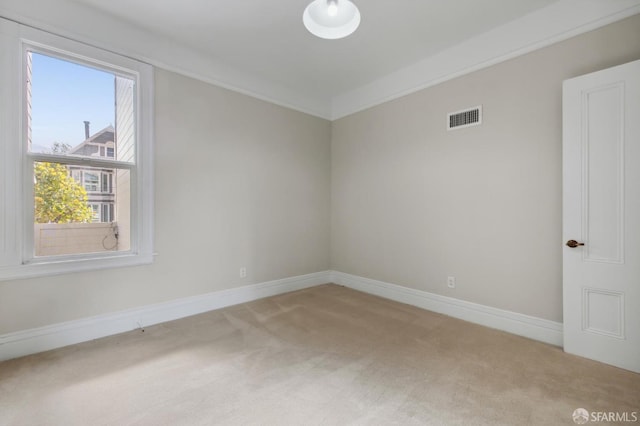 carpeted empty room featuring crown molding