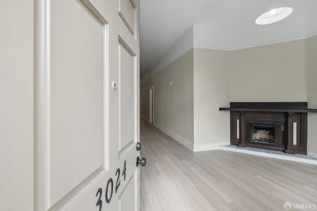 unfurnished living room with crown molding and light wood-type flooring