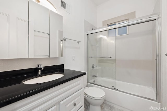 full bathroom with toilet, enclosed tub / shower combo, and vanity