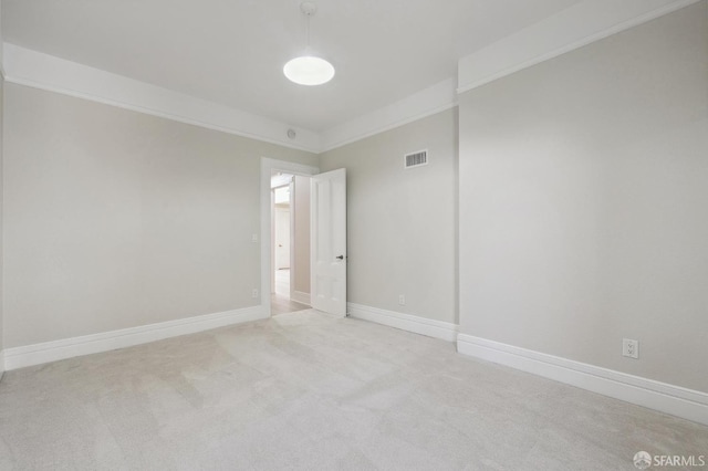 empty room with crown molding and light carpet