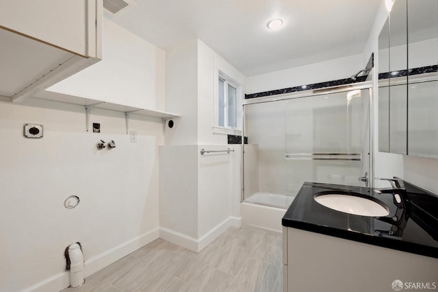 bathroom with vanity and shower / bath combination with glass door