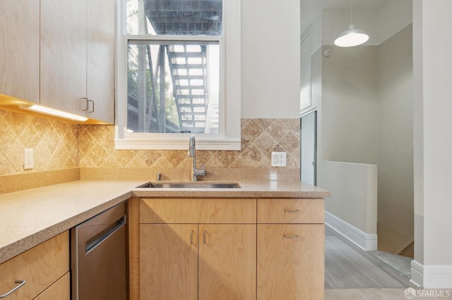 kitchen with decorative backsplash, stainless steel dishwasher, light brown cabinets, and sink