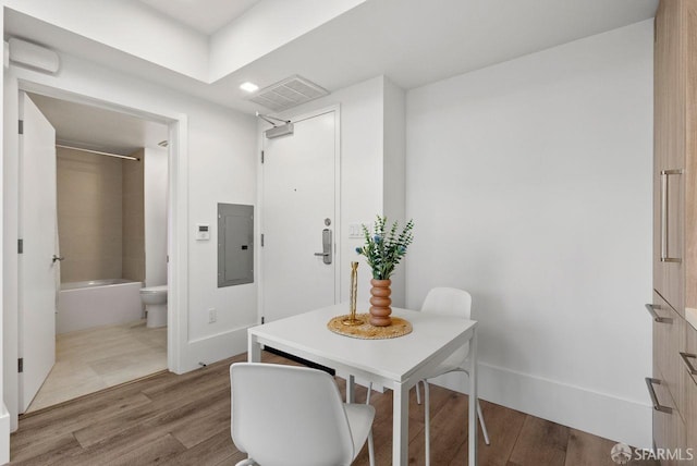 dining area with wood-type flooring and electric panel