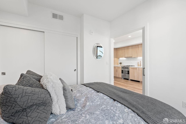 bedroom featuring light wood-type flooring and a closet