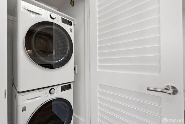 washroom with stacked washing maching and dryer