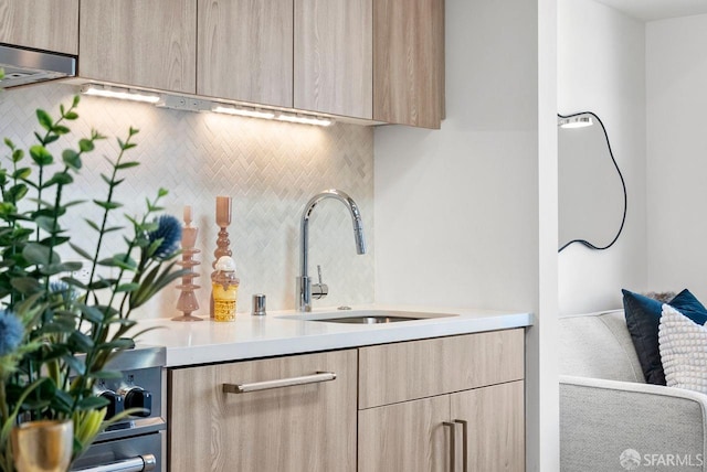 kitchen featuring light brown cabinetry, sink, and decorative backsplash