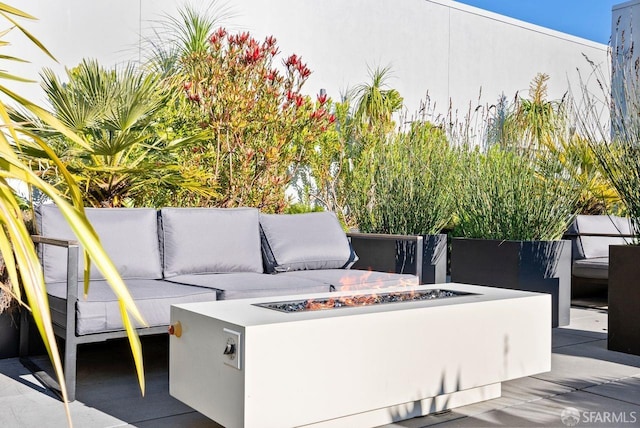 view of patio with an outdoor living space with a fire pit