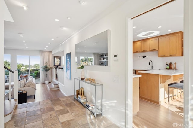 interior space featuring a breakfast bar, sink, light wood-type flooring, and kitchen peninsula