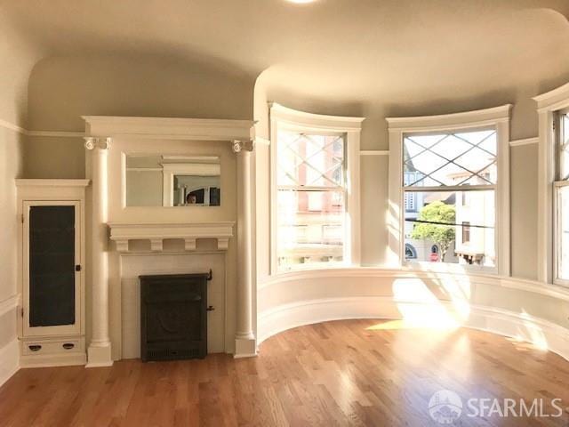 unfurnished living room with a fireplace and wood finished floors