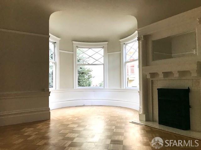 unfurnished living room featuring a fireplace and a decorative wall