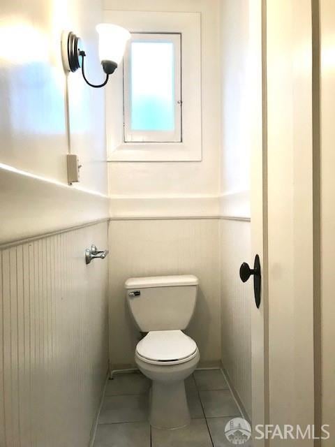 bathroom featuring tile patterned flooring and a wainscoted wall