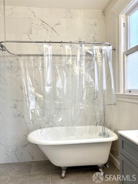 bathroom with vanity and a soaking tub