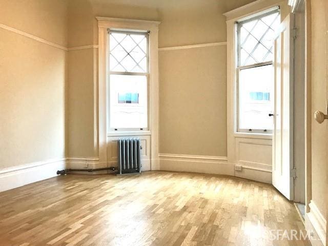 empty room featuring radiator and wood finished floors
