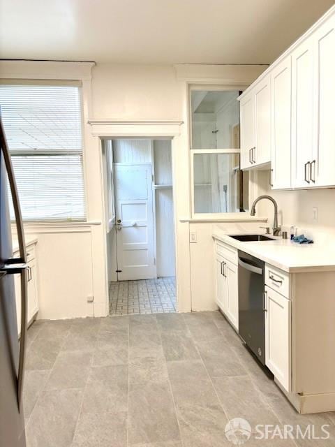 kitchen with dishwasher, white cabinetry, light countertops, and light tile patterned floors