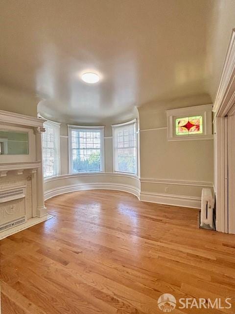 unfurnished living room featuring wood finished floors and baseboards