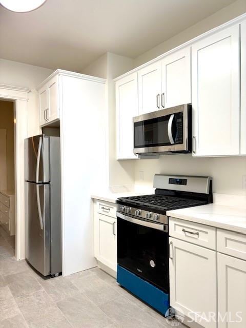 kitchen with appliances with stainless steel finishes, white cabinets, and light countertops