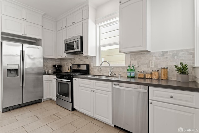 kitchen with white cabinets, stainless steel appliances, tasteful backsplash, and sink