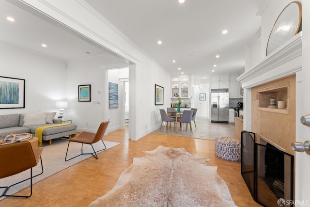 living room featuring crown molding and light hardwood / wood-style flooring