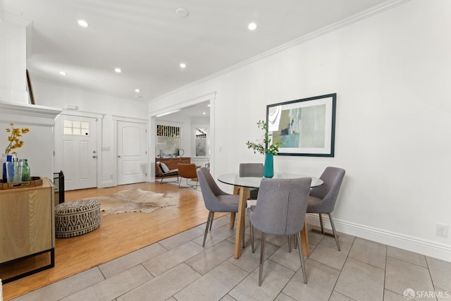 dining space with crown molding and light hardwood / wood-style flooring