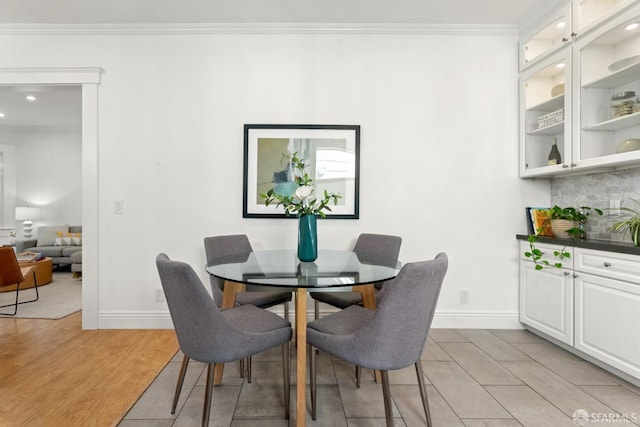 dining area featuring light hardwood / wood-style floors and ornamental molding