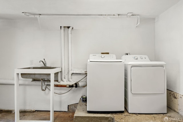 clothes washing area featuring washer and dryer and sink