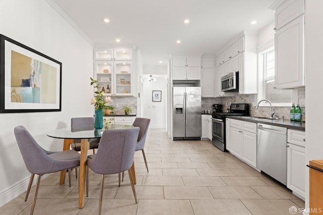 kitchen with white cabinets, sink, stainless steel appliances, and tasteful backsplash