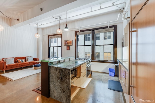 kitchen with hanging light fixtures, dark stone counters, high quality appliances, and a center island