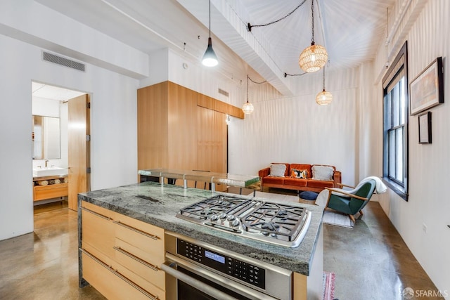 kitchen with concrete flooring, stainless steel appliances, and pendant lighting