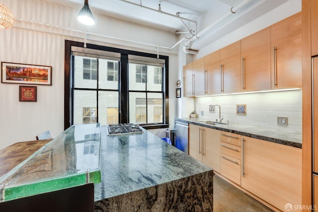 kitchen featuring appliances with stainless steel finishes, light brown cabinets, dark stone counters, and sink