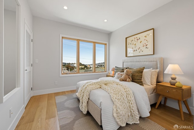 bedroom with light wood-style floors, baseboards, and recessed lighting