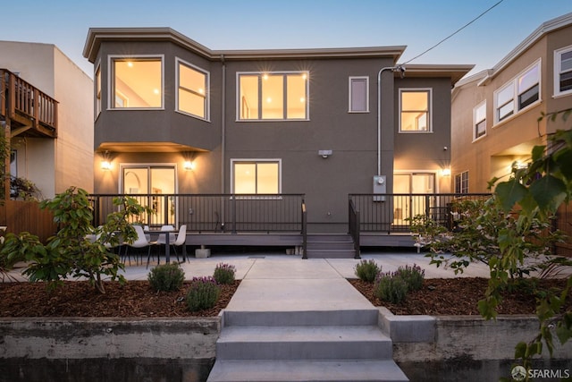 rear view of property with stucco siding and a patio
