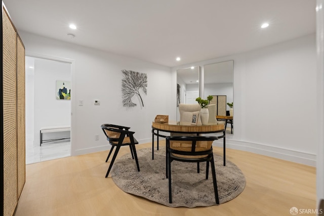 dining room with recessed lighting, baseboards, and light wood-style floors