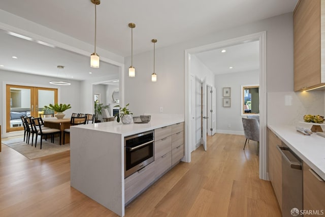 kitchen featuring modern cabinets, stainless steel appliances, light wood-style flooring, light countertops, and recessed lighting