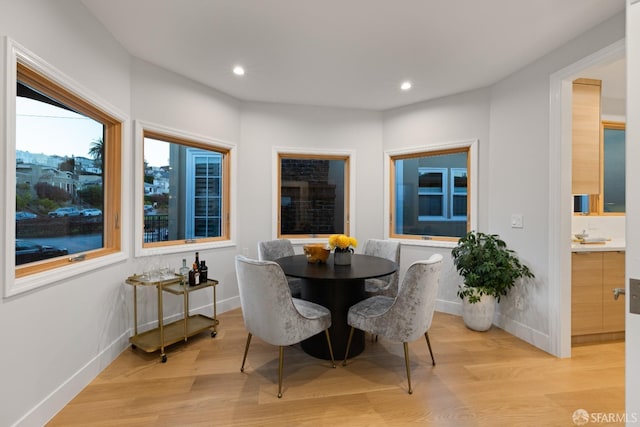 dining room featuring light wood finished floors, baseboards, and recessed lighting
