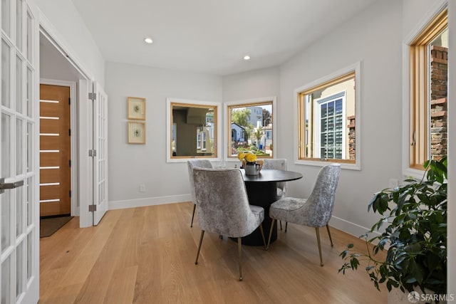 dining space featuring light wood-style floors, baseboards, recessed lighting, and french doors