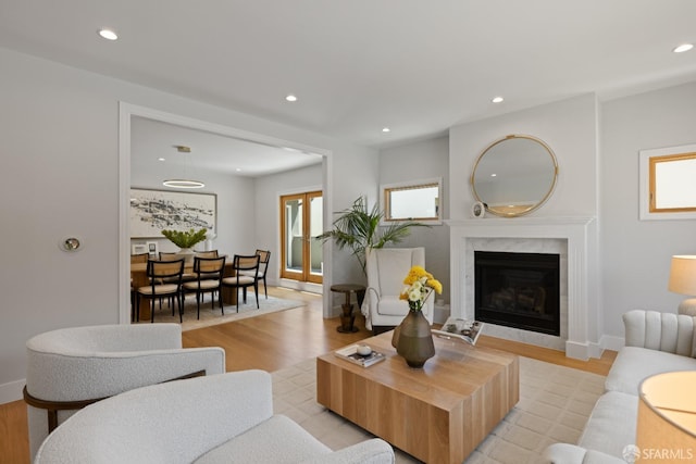 living area featuring recessed lighting, light wood-style flooring, a fireplace, and baseboards