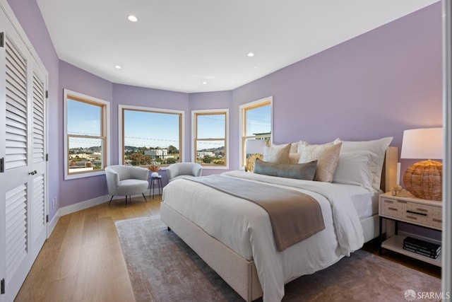 bedroom featuring wood finished floors, recessed lighting, and baseboards