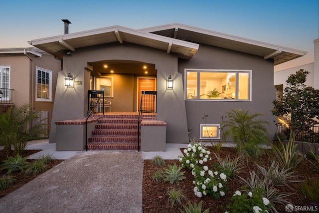 view of front of house featuring stucco siding and a porch