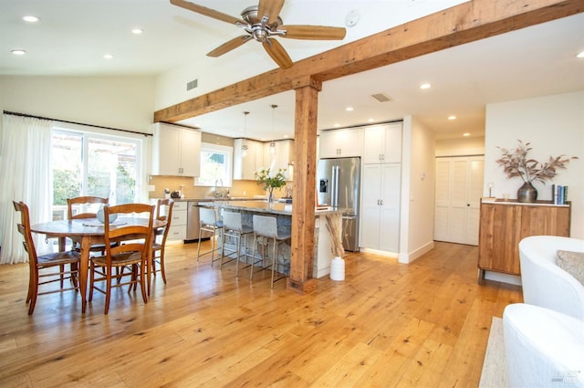 dining space featuring visible vents, light wood-style flooring, lofted ceiling, and recessed lighting