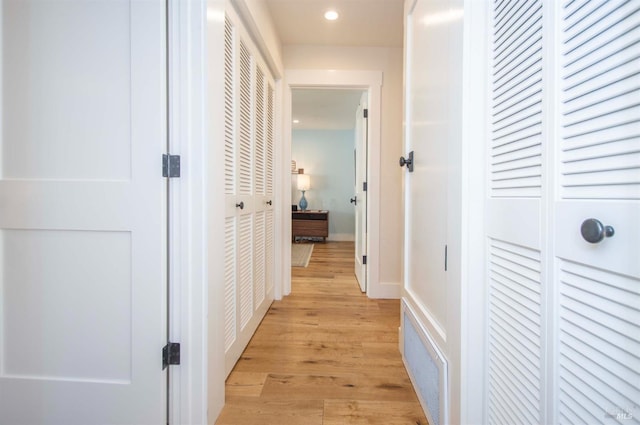 hall featuring light wood finished floors and recessed lighting