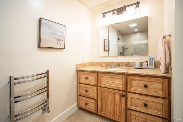 bathroom featuring tile patterned floors, a shower stall, baseboards, and vanity
