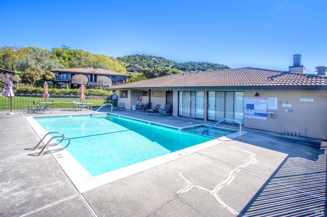 community pool featuring a patio area and fence
